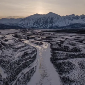 Scenic Winding Roads in Yukon's Forest with Majestic Mountains in the Background